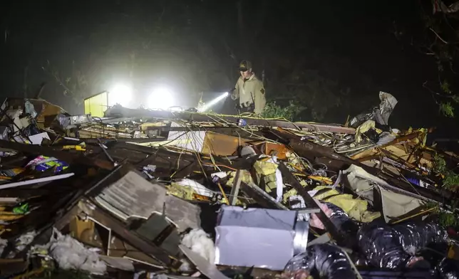 An Oklahoma State Highway Patrol trooper searches storm damage Tuesday, May 7, 2024 in Barnsdall, Okla. (Mike Simons/Tulsa World via AP)