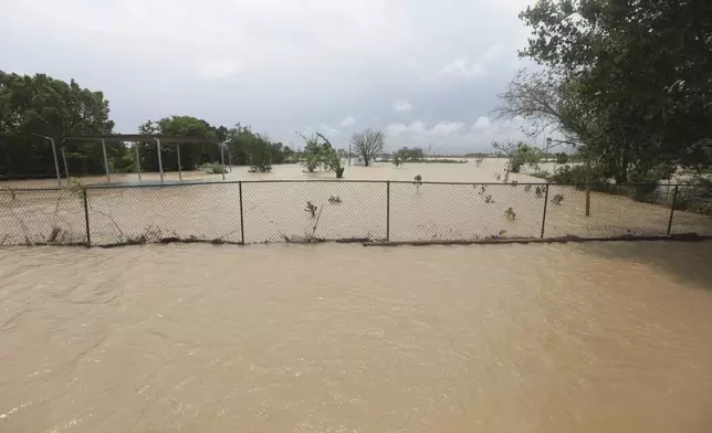 A mobile home in an unincorporated area in east Harris County near Houston on Sunday morning, May 5, 2024, is surrounded by flood waters caused by the nearby San Jacinto River, which overflowed due to heavy rainfall earlier this week. (AP Photo/Lekan Oyekanmi)