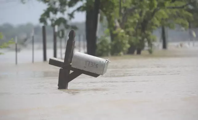 A mailbox is partially submerged on a flooded street in an unincorporated area in east Harris County near Houston on Sunday morning, May 5, 2024. The nearby San Jacinto River, overflowing due to heavy rainfall earlier this week, caused the flood waters. (AP Photo/Lekan Oyekanmi)