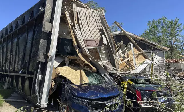 A mobile park home flipped onto two nearby cars after a tornado struck Pavilion Estates near Kalamazoo, Mich. on Wednesday, May 8, 2024. (AP Photo/Joey Cappelletti)
