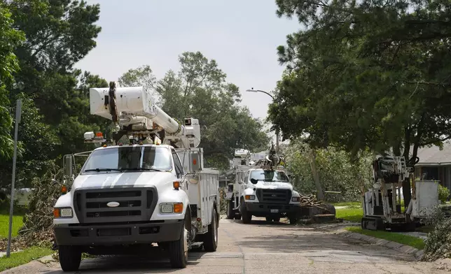 Utility trucks line Grovewood Lane to assist recovery from last week's severe storms, Tuesday, May 21, 2024, at Timbergrove in Houston. (Yi-Chin Lee/Houston Chronicle via AP)