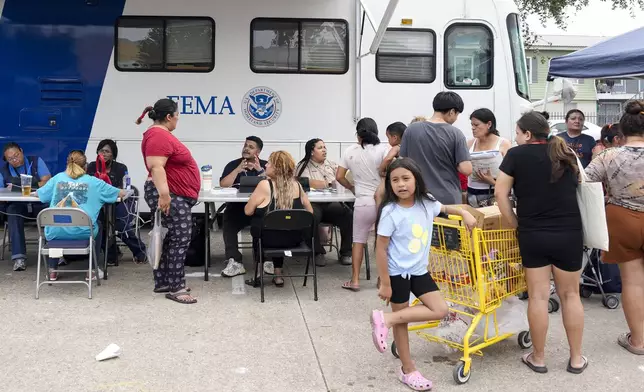 People affected by recent severe storms wait in line for assistance at a FEMA mobile unit Tuesday, May 21, 2024, at Spring Branch Family Development Center in Houston. (Yi-Chin Lee/Houston Chronicle via AP)