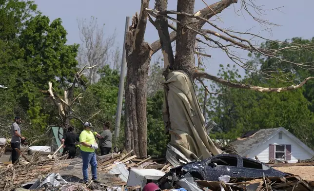 Workers survey the damage of a tornado damaged home, Wednesday, May 22, 2024, in Greenfield, Iowa. (AP Photo/Charlie Neibergall)