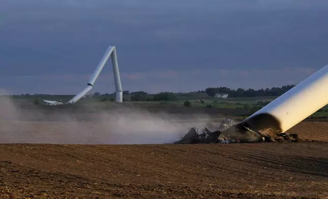 The remains of two tornado-damaged wind turbine touch the ground in a field, Tuesday, May 21, 2024, near Prescott, Iowa. (AP Photo/Charlie Neibergall)