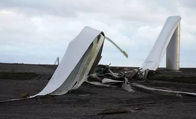 The remains of a tornado-damaged wind turbine touch the ground in a field, Tuesday, May 21, 2024, near Prescott, Iowa. (AP Photo/Charlie Neibergall)