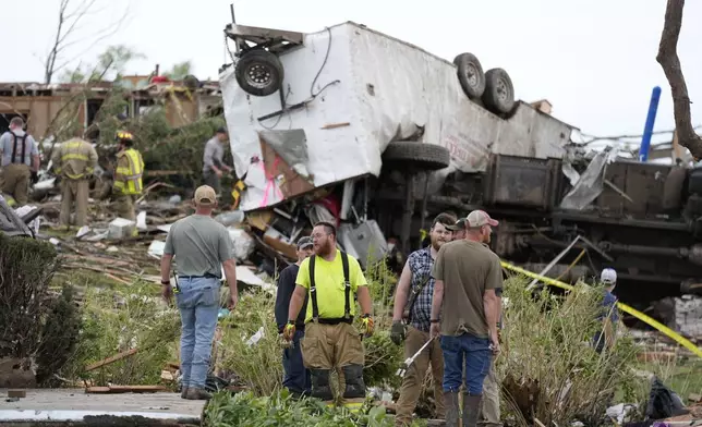 Workers search through the remains of tornado-damaged property, Tuesday, May 21, 2024, in Greenfield, Iowa. (AP Photo/Charlie Neibergall)