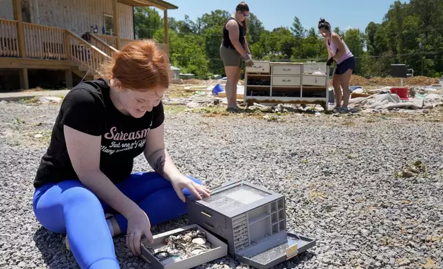 Haley Loukota, smiles as she finds her grandmother's wedding rings after they were located among storm debris along Barnsley Loop, Tuesday, May 28, 2024, in Madisonville, Ky. Her home was demolished after series of powerful storms hit the central and southern U.S. over the Memorial Day holiday weekend. (AP Photo/George Walker IV)