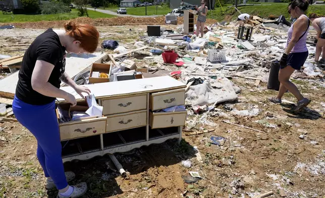 Haley Loukota, searches for her belongings among storm debris along Barnsley Loop, Tuesday, May 28, 2024, in Madisonville, Ky. Her home was demolished after a series of powerful storms hit the central and southern U.S. over the Memorial Day holiday weekend. (AP Photo/George Walker IV)