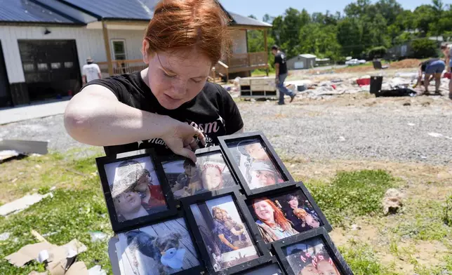 Haley Loukota, looks over family photographs found among storm debris from her demolished home along Barnsley Loop, Tuesday, May 28, 2024, in Madisonville, Ky. A series of powerful storms hit the central and southern U.S. over the Memorial Day holiday weekend. (AP Photo/George Walker IV)