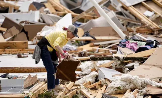 Valerie Bernhardt looks through debris at her stormed damaged home Thursday, May 9, 2024, in Columbia, Tenn. A wave of dangerous storms began crashing over parts of the South on Thursday, a day after severe weather with damaging tornadoes killed at least several people in the region. (AP Photo/George Walker IV)