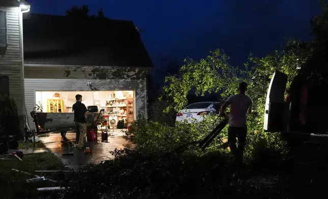 Residents work to remove downed trees at their home along Cothran Road after severe storms tore through the area, Wednesday, May 8, 2024, in Columbia, Tenn. (AP Photo/George Walker IV)