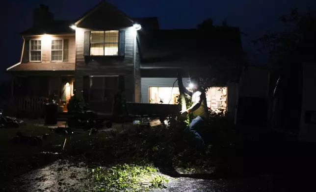Charles Hodge works to clear storm damage at a home along Cothran Road, Wednesday, May 8, 2024, in Columbia, Tenn. (AP Photo/George Walker IV)