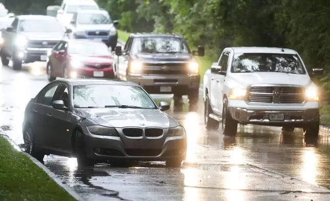 Traffic goes around a stalled car on Kingwood Drive after severe flooding, Thursday, May 2, 2024, in the Houston neighborhood of Kingwood, Texas. (Jason Fochtman/Houston Chronicle via AP)