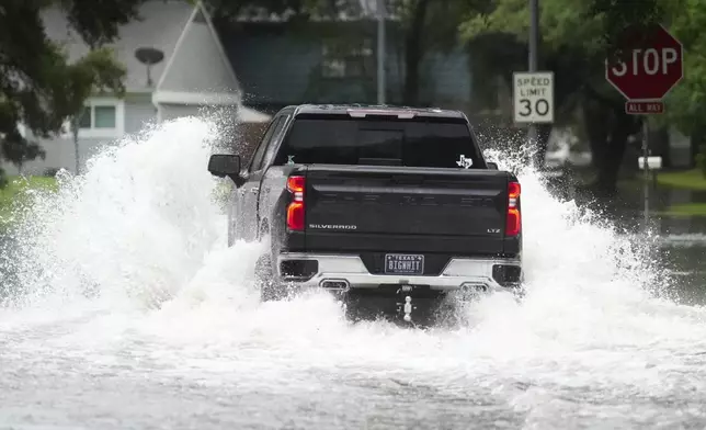 A truck drives through flood water in North Woodland Hills after severe flooding, Thursday, May 2, 2024, in the Houston neighborhood of Kingwood, Texas. (Jason Fochtman/Houston Chronicle via AP)