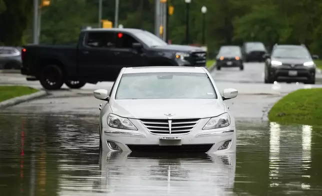 A stalled car is seen in flood water near North Park Drive after severe flooding, Thursday, May 2, 2024, in the Houston neighborhood of Kingwood, Texas. (Jason Fochtman/Houston Chronicle via AP)