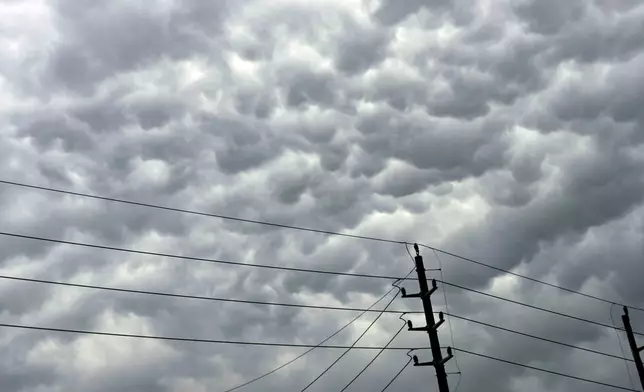 Clouds amass over power lines follow days of storms on Sunday, May 5, 2024, in Humble, Texas. (Elizabeth Conley/Houston Chronicle via AP)