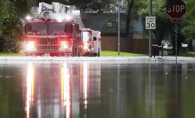 A Houston firetruck makes it way through flood water in North Woodland Hills after severe flooding, Thursday, May 2, 2024, in the Houston neighborhood of Kingwood, Texas. (Jason Fochtman/Houston Chronicle via AP)