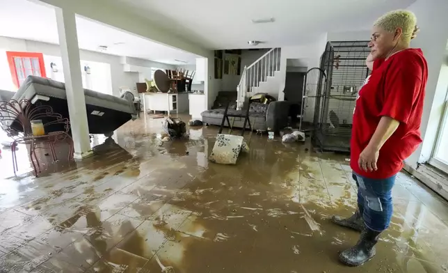 Yanira Diaz stands in her muddy living room as she begins the clean up process of her flood-damaged home in the River Plantation neighborhood on Monday, May 6, 2024, in Conroe, Texas. (Brett Coomer/Houston Chronicle via AP)