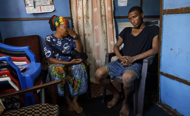 Memunatu Kamara breaks down in tears next to her son Mohammed, who smokes Kush in Susan's Bay, one of the three largest slums in Freetown, Sierra Leone, Sunday, April 28, 2024. Kamala said it's a shame for her to see her son going wasteful due to Kush's addiction. Sierra Leone declared a war on the cheap synthetic drug, calling it an epidemic and a national threat. The drug is ravaging youth, and healthcare services are severely limited. (AP Photo/ Misper Apawu)