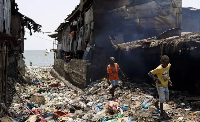 Two boys walk in Moa Wharf, a slum where Kush users live in Freetown, Sierra Leone, Friday, April 26, 2024. Sierra Leone declared a war on Kush, a cheap synthetic drug, calling it an epidemic and a national threat. The drug is ravaging youth, and healthcare services are severely limited. (AP Photo/ Misper Apawu)