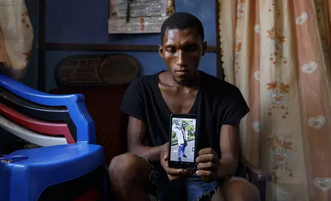 Mohammed Kamara, a Kush user, shows a picture of himself before he got addicted to Kush and dropped out of school at his family's home in Susan's Bay, one of the three largest slums in Freetown, Sierra Leone, Sunday, April 28, 2024 Kamara fell to peer pressure and dropped out of school when he was in Senior High. "I want to go back to school", says Mohammed, and pursue my mechanical engineering dream."Sierra Leone declared a war on the cheap synthetic drug, calling it an epidemic and a national threat. The drug is ravaging youth, and healthcare services are severely limited. (AP Photo/ Misper Apawu)