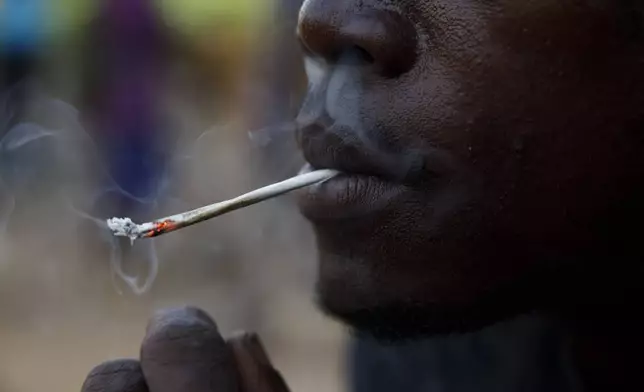 A young man smokes Kush at a hideout in Freetown, Sierra Leone, Monday, April 29, 2024. Sierra Leone declared a war on the cheap synthetic drug, calling it an epidemic and a national threat. The drug is ravaging youth, and healthcare services are severely limited. (AP Photo/ Misper Apawu)