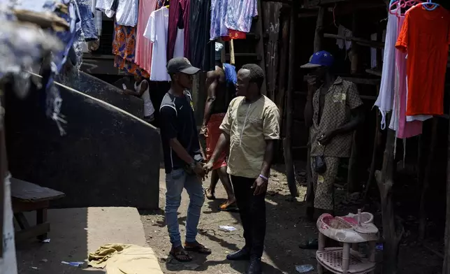 Ephraim Maculey, (R), a former Kush user and now an anti-drug activist, talks with drug users at a drug den in Freetown, Sierra Leone, Friday, April 26, 2024. Maculey is an employee of Sierra Leone's Youth Development and Child Link (SLYDCL), an organisation that provides medical care and psychological services to drug users in Sierra Leone. (AP Photo/ Misper Apawu)