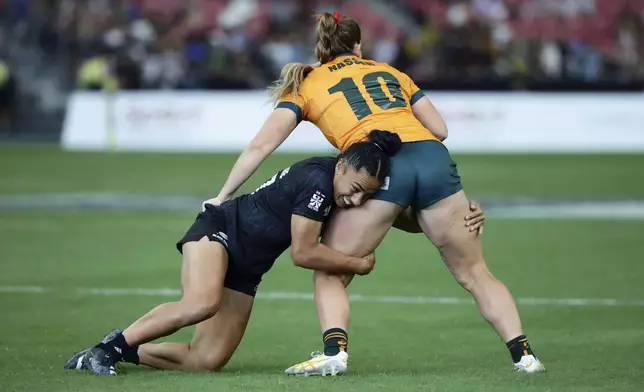 Risi Pouri-Lane of New Zealand tackles Isabella Nasser of Australia during the women's World Rugby Sevens Series 2024 cup final between Australia and New Zealand, in Singapore, on Sunday, May 5, 2024. (AP Photo/Suhaimi Abdullah)