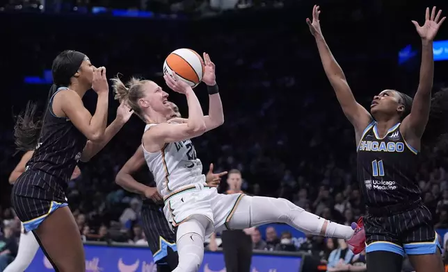 New York Liberty's Courtney Vandersloot (22) shoots from between Chicago Sky's Dana Evans (11) and Angel Reese, left, during the first half of a WNBA basketball game Thursday, May 23, 2024, in New York. (AP Photo/Frank Franklin II)
