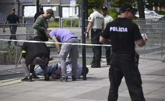 Police arrest a man after Slovak Prime Minister Robert Fico was shot and injured following the cabinet's away-from-home session in the town of Handlova, Slovakia, Wednesday, May 15, 2024. Fico is in life-threatening condition after being wounded in a shooting Wednesday afternoon, according to his Facebook profile. (Radovan Stoklasa/TASR via AP)