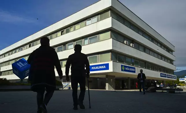 People walk outside the F. D. Roosevelt University Hospital, where Slovak Prime Minister Robert Fico, who was shot and injured, is treated in Banska Bystrica, central Slovakia, Thursday, May 16, 2024. Slovakia's populist Prime Minister Robert Fico was shot multiple times and gravely wounded Wednesday, but his deputy prime minister said he believed Fico would survive. (AP Photo/Denes Erdos)