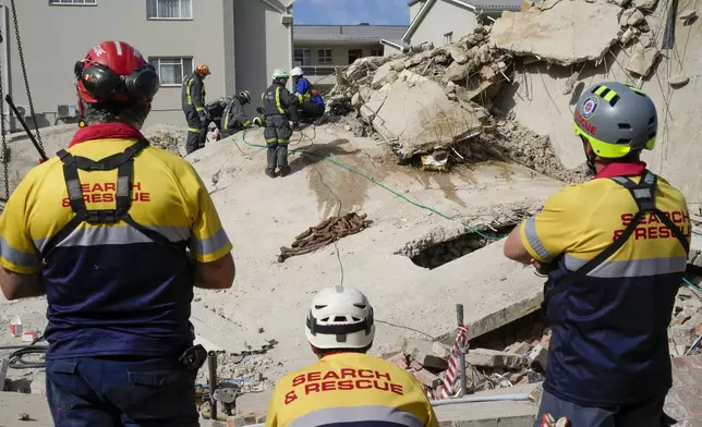 Rescue workers search the site of a building collapse in George, South Africa, Wednesday, May 8, 2024. Rescue teams are searching for dozens of construction workers missing after a multi-story apartment complex collapsed in the coastal city have brought out more survivors as the operation entered a second night of desperate work to find anyone alive in the mangled wreckage. (AP Photo/Jerome Delay)