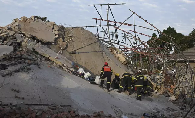 Emergency workers on the scene of a collapsed building in George, South Africa, Tuesday, May 7, 2024. Five workers have been killed with 49 still trapped after the building under construction collapsed Monday. (AP Photo)