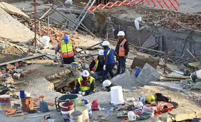 Emergency workers on the scene of a collapsed building in George, South Africa, Tuesday, May 7, 2024. Five workers have been killed with 49 still trapped after the building under construction collapsed Monday. (AP Photo)