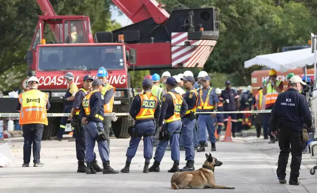 Rescue teams at the site of a building collapse in George, South Africa, Wednesday, May 8, 2024. Rescue teams are into a third day searching for dozens of construction workers buried in the rubble of an unfinished five-story apartment building that collapsed in South Africa. (AP Photo/Nardus Engelbrecht)