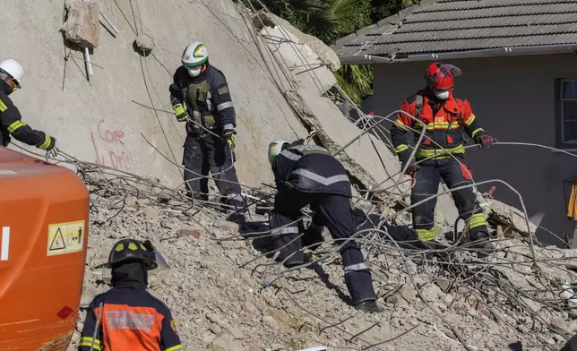 Rescue personnel search the site of a building collapse in George, South Africa, Thursday, May 9, 2024. Rescue teams, searching for dozens of construction workers missing after a multi-story apartment complex collapsed in the coastal city, have not brought out more survivors in the past 24 hours. (AP Photo/Jerome Delay)