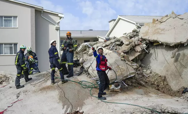 Rescue workers search the site of a building collapse in George, South Africa, Wednesday, May 8, 2024. Rescue teams are searching for dozens of construction workers missing after a multi-story apartment complex collapsed in the coastal city have brought out more survivors as the operation entered a second night of desperate work to find anyone alive in the mangled wreckage. (AP Photo/Jerome Delay)