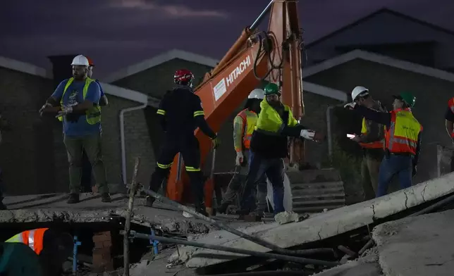 Rescue workers search the site of a building collapse in George, South Africa, Wednesday, May 8, 2024. Nearly 40 construction workers were still missing Wednesday in the rubble of a building that collapsed in South Africa on Monday as rescue teams continued to search for survivors for a third day in the wreckage of the unfinished five-story apartment complex. (AP Photo/Jerome Delay)