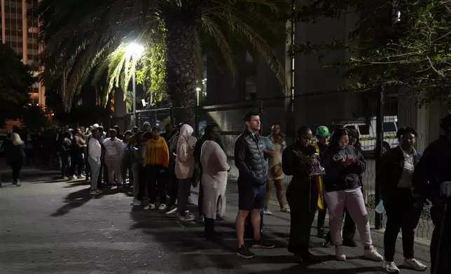 People queue after dark to cast their votes at a polling station in Cape Town, South Africa, Wednesday, May 29, 2024. South Africans voted Wednesday at schools, community centers, and in large white tents set up in open fields in an election seen as their country’s most important since apartheid ended 30 years ago. It could put the young democracy into unknown territory. (AP Photo/Nardus Engelbrecht)