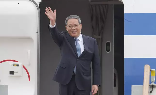 Chinese Premier Li Qiang waves to media members upon his arrival for trilateral meetings at the Seoul airport in Seongnam, South Korea, Sunday, May 26, 2024. Leaders of South Korea, China and Japan will meet next week in Seoul for their first trilateral talks since 2019. (AP Photo/Lee Jin-man)