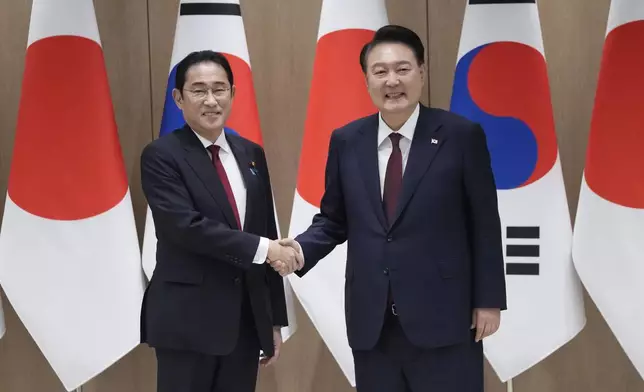 South Korean President Yoon Suk Yeol, right, shakes hands with Japanese Prime Minister Fumio Kishida during a meeting at the Presidential Office in Seoul, South Korea, Sunday, May 26, 2024. (AP Photo/Ahn Young-joon, Pool)