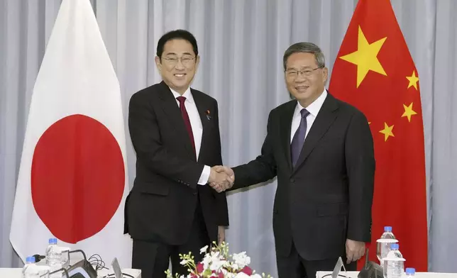 Japanese Prime Minister Fumio Kishida, left, shakes hands with Chinese Premier Li Qiang before their meeting in Seoul, South Korea, Sunday, May 26, 2024. (Daisuke Suzuki/Kyodo News via AP)