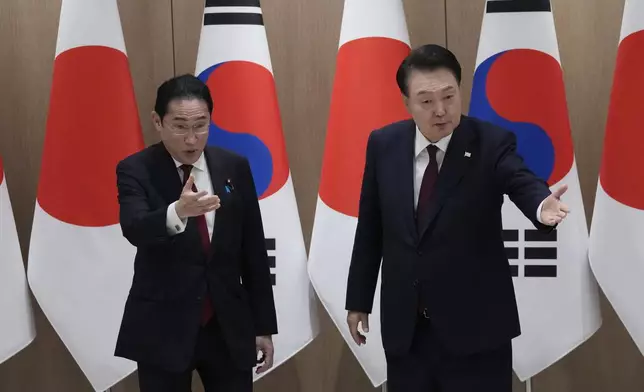 South Korean President Yoon Suk Yeol, right, and Japanese Prime Minister Fumio Kishida gesture during a meeting at the Presidential Office in Seoul, South Korea, Sunday, May 26, 2024. (AP Photo/Ahn Young-joon, Pool)
