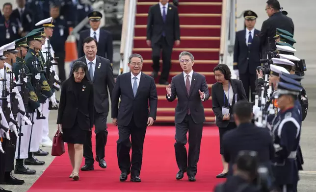 Chinese Premier Li Qiang, center left, is welcomed by Kim Hong-kyun, right, South Korean 1st vice minister, as the premier arrives for a trilateral meeting at the Seoul airport in Seongnam, South Korea, Sunday, May 26, 2024. Leaders of South Korea, China and Japan will meet next week in Seoul for their first trilateral talks since 2019. (AP Photo/Lee Jin-man)