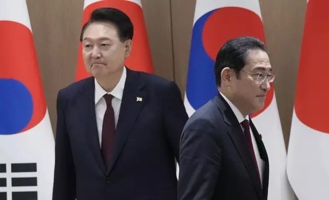 South Korean President Yoon Suk Yeol, left, and Japanese Prime Minister Fumio Kishida move their positions during a meeting at the Presidential Office in Seoul, South Korea, Sunday, May 26, 2024. (AP Photo/Ahn Young-joon, Pool)