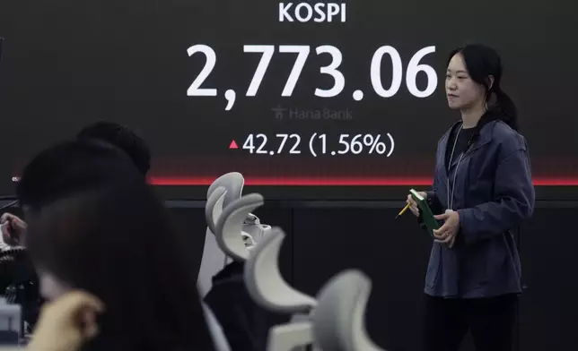 A currency trader passes by the screen showing the Korea Composite Stock Price Index (KOSPI) at the foreign exchange dealing room of the KEB Hana Bank headquarters in Seoul, South Korea, Thursday, May 16, 2024. (AP Photo/Ahn Young-joon)