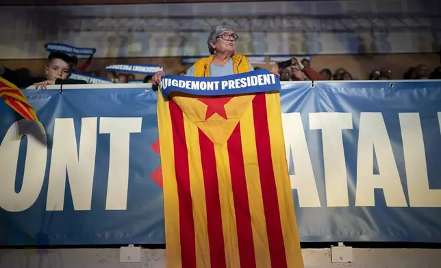 A supporter of Catalonia's former regional president Carles Puigdemont holds a "estelada" or Independence flag, during a campaign rally in Argelers, France, Wednesday, May 8, 2024. Carles Puidgemont, Catalonia's fugitive former leader, stares confidently out the backseat window of a car, the sun illuminating his gaze in a campaign poster for Sunday's critical elections in the northeastern Spanish region. Some nearly 6 million Catalans are called to cast ballots in regional elections on Sunday that will surely have reverberations in Spain's national politics. (AP Photo/Joan Mateu)