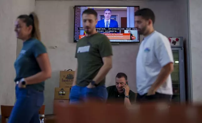 Customers stand in a restaurant while Spanish Prime Minister Pedro Sanchez appears on a television broadcast in Rivas Vaciamadrid, Spain, Tuesday, May 28, 2024. Prime Minister Pedro Sanchez says the Spanish Cabinet will recognize a Palestinian state at its Tuesday morning meeting as a European Union rift with Israel widens. (AP Photo/Manu Fernandez)