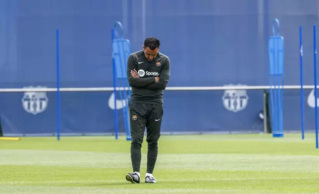 Barcelona's head coach Xavi Hernandez looks down during a training session in Barcelona, Spain, Saturday, May 25, 2024. Barcelona says coach Xavi Hernandez is leaving the club at the end of the season. The club made the announcement on Friday after a meeting between club president Joan Laporta, Xavi and other senior figures at the team training ground. (AP Photo/Joan Monfort)
