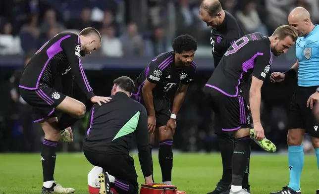 Bayern's Serge Gnabry, center, gestures as he leaves the pitch after being injured during the Champions League semifinal second leg soccer match between Real Madrid and Bayern Munich at the Santiago Bernabeu stadium in Madrid, Spain, Wednesday, May 8, 2024. (AP Photo/Manu Fernandez)
